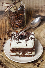 Chocolate and cherry cake. Coffee beans around, wooden back
