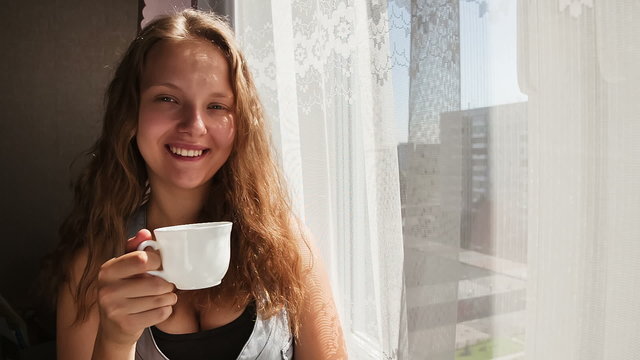Woman at the window with a cup of coffee