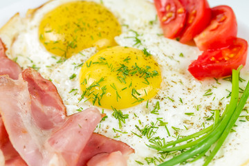 Fried eggs with ham and tomatoes