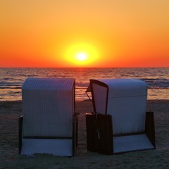 zwei Strandkörbe bei Sonnenaufgang