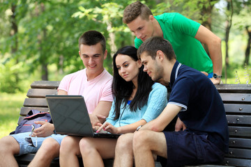 four smiling student studying in green park