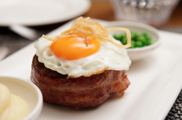Tenderloin steak with fried egg and green pies