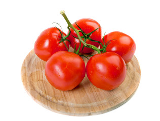 Cherry tomatoes on branch at cutting kitchen board