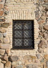 Fototapeta na wymiar iron bar retro okna chronią dom murowany z kamienia
