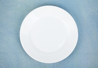 Empty white plate on wooden table