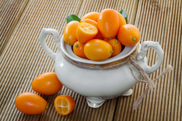 Ripe kumyauat with leaves in a bowl