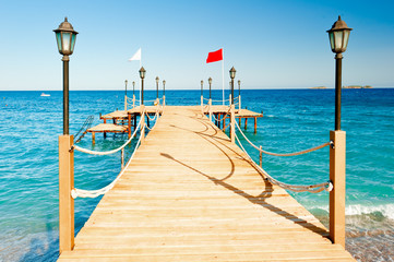 Naklejka premium light poles and rope fence on wooden pier