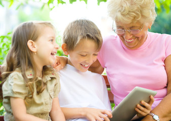 grandmother with grandchildren using tablet PC