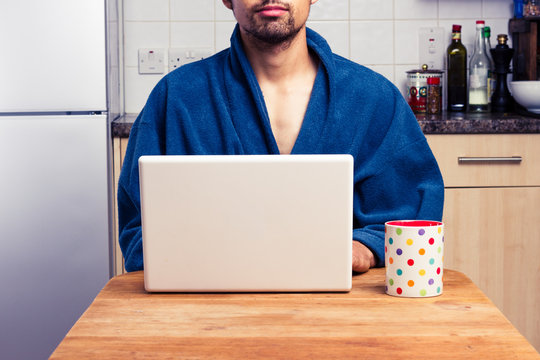 Man in robe working from home