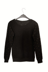 It is a black sweater with golden decor.