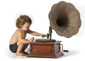 Baby sits and plays with an old gramophone