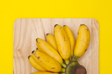 Fototapeta na wymiar banana on chopping with yellow background