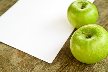 Green apples and white paper
