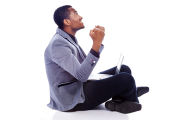 Winner business man with laptop sitting on the floor - isolated