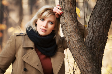Sad beautiful woman in autumn forest