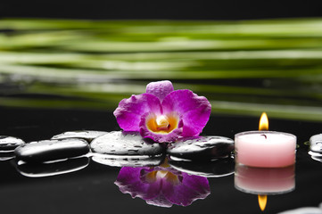 Plakat spa concept- orchid and black stones with palm leaf and candle