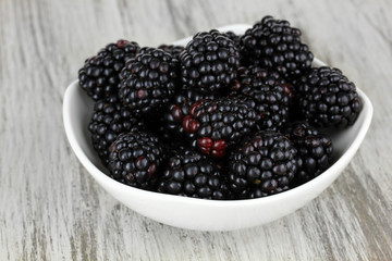 Sweet blackberries in bowl on table close-up