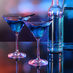 Glasses of cocktails on bright background