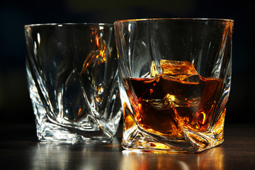 Glasses of whiskey, on dark background