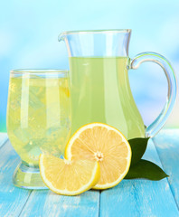 Delicious lemonade on table on blue background