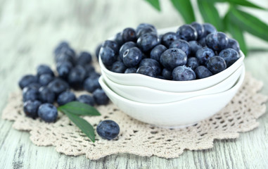 Blueberries in plates on napkin on wooden background
