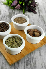 Assortment of spices in  white  bowls, on wooden background