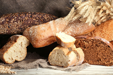 Much bread on wooden board on  wicker tray background