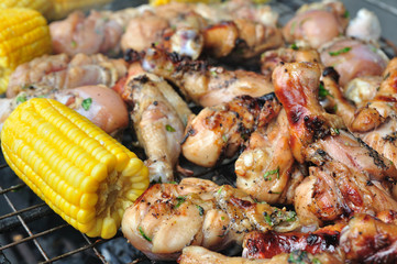 Chicken thighs and sweet corns be ripe by flaming on the sieve.