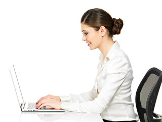 woman sits from the  table and working on laptop