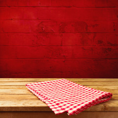 Vintage wooden table with tablecloth over red brick stone wall