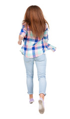 back view of running  woman. beautiful redhead girl in motion.