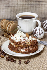 Tiramisu cake on hessian napkin. Coffee beans around.