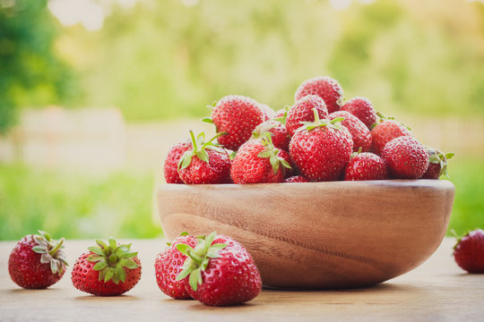 Close-Up Of Strawberries In Vintage Wooden Bowl On Table