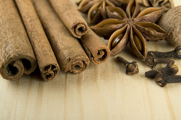 Cinnamon sticks, nutmeg, cloves and anise stars over wood