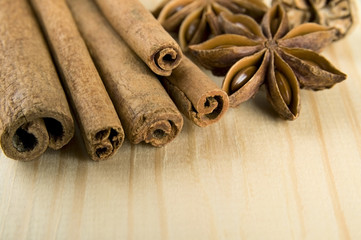 Cinnamon sticks, nutmeg and anise stars over wooden background