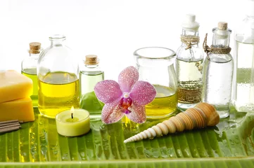 Schilderijen op glas Health spa with massage oil and pink orchid on leaf © Mee Ting