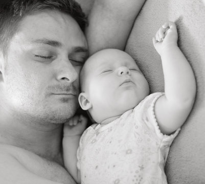 Father sleep with his baby.
