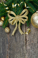 golden ribbon and twig of fir on wooden surface