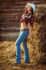 Naklejka na ściany i meble cowgirl model posing on farm