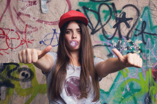 trendy beautiful long haired model posing on graffiti