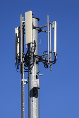 Cell tower and radio antenna on blue sky