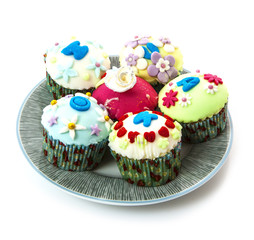 Cupcakes with spring flowers on white isolated background