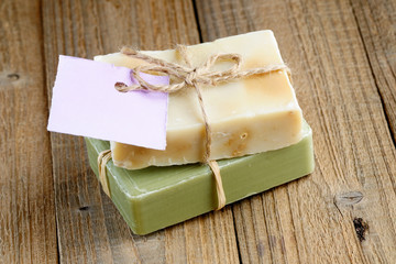 Two natural soap bars with tag on wooden background