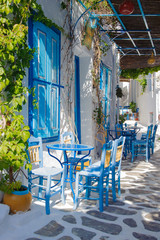Greek old town back street tavern with traditional white and blue colors