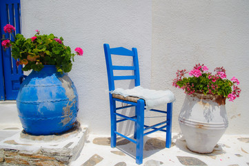 Greek traditional blue chair and flower pots