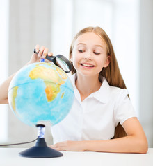 child looking at globe with magnifier