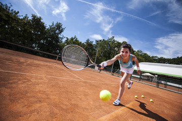 Young girl playing tennis on court