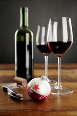 Two glasses of red wine and christmas baubel