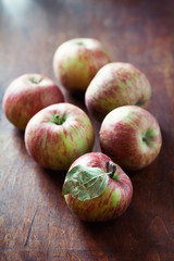 Ripe red apples on a old wooden table .