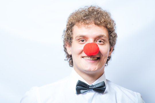 Young studen or Businessman with a red clown nose. Studio shot.